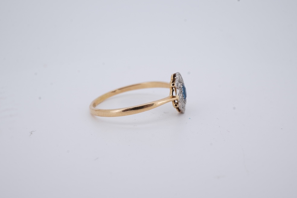 A 1920's yellow metal, stamped 18ct, sapphire and diamond set oval cluster ring, size V, gross weight 2.3 grams. Condition - poor to fair